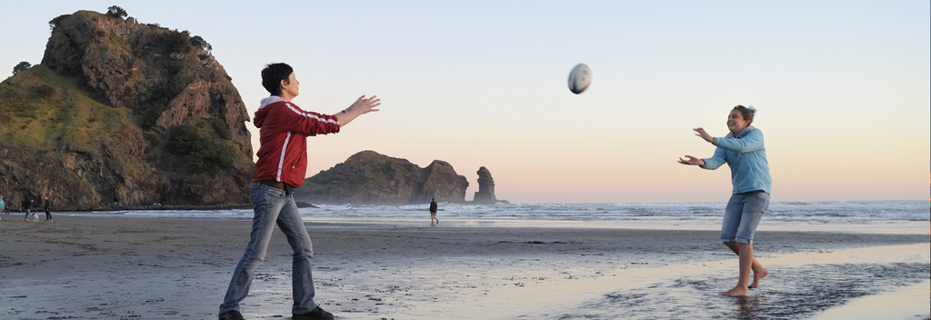 Ein wilder neuseeländischer Strand ist ein großartiger Ort, um einem Rugbyball herum zu werfen.
